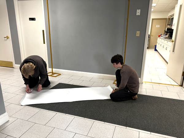 Anchor Homeschool Co-op students setting up a welcome banner before an event